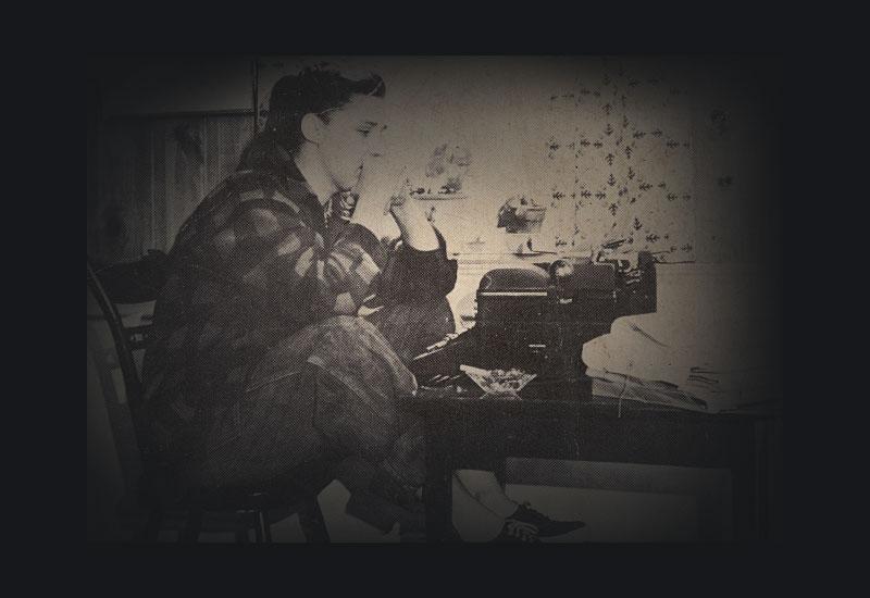 Grace Metalious sitting in front of her typewriter.