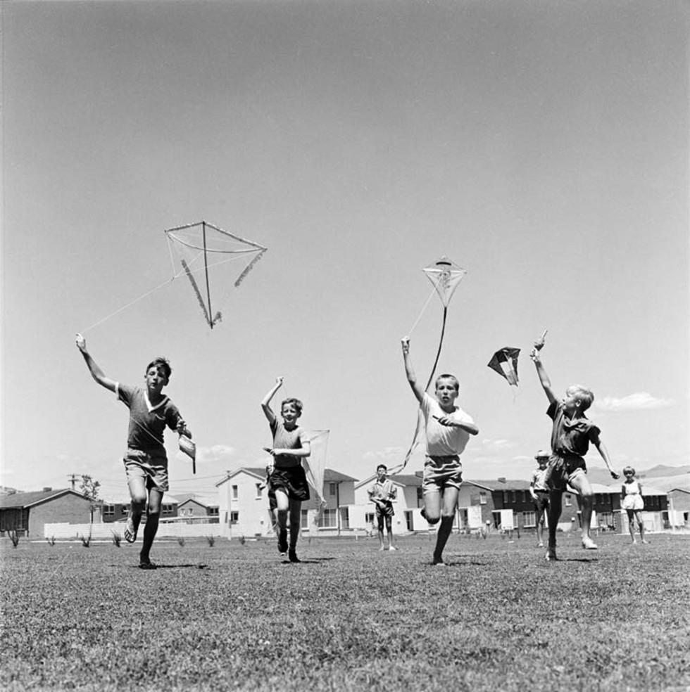 Children flying kites at school.