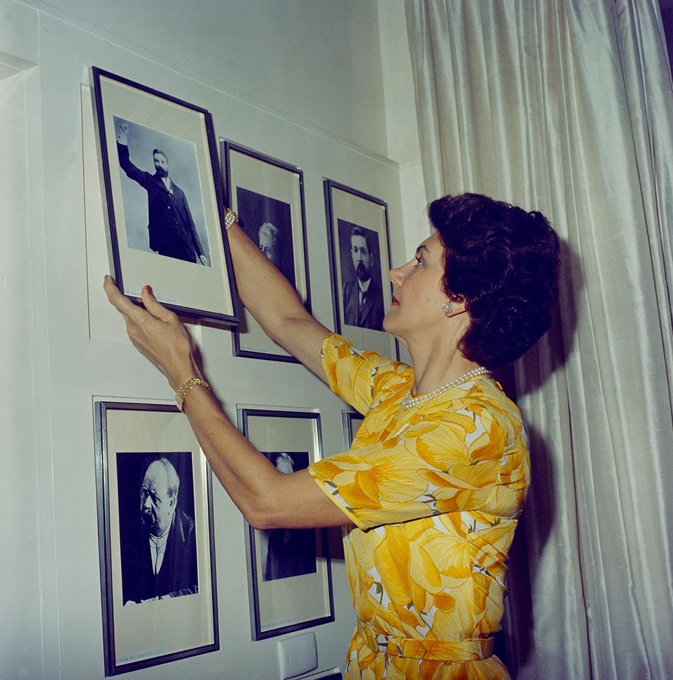 Tamie Fraser adjusting photographs on a wall.