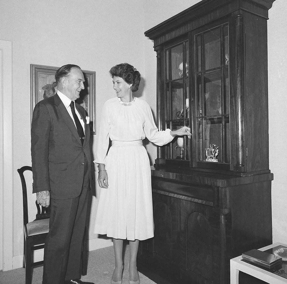 Clement Conger and Tamie Fraser standing next to a sideboard at the lodge.