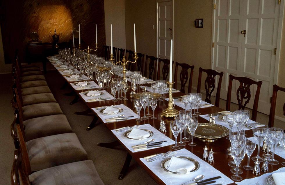 Official dining room and table at the lodge set with silverware, glasses and candles.