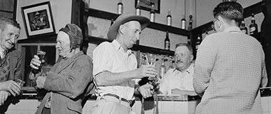 Barman and four men standing at a public bar.