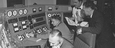 Four men, Australian and American scientists in the control room of Australia's radio telescope at Parkes. 