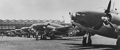 RAAF Lockheed Hudson bombers on an airfield. Aircraft hangar in the background.