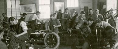 Men working at a car repair class.