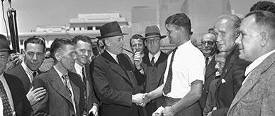 British migrant tradesman shakes hands with Prime Minister Ben Chifley.