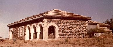 Stone building with triple arched portico.