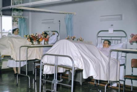 A woman with her legs elevated in a hospital bed.